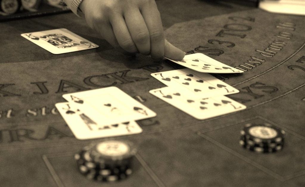 sepia photo of man dealing cards during game of blackjack