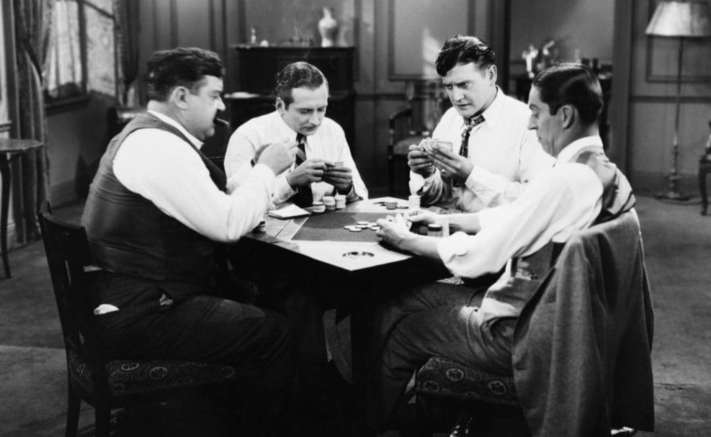 black and white photo of group of men playing poker around a table 