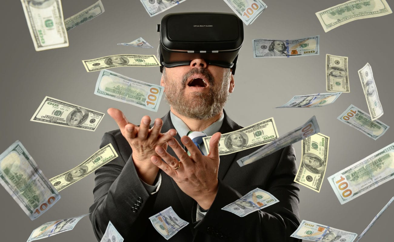 A person in a suit wearing a virtual reality headset with money flying all around them.
