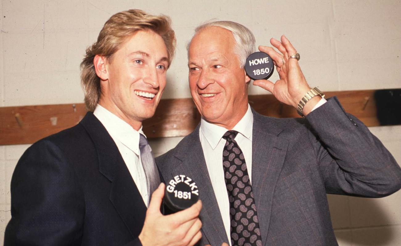 Gordie Howe and Wayne Gretzky with pucks in their hand
