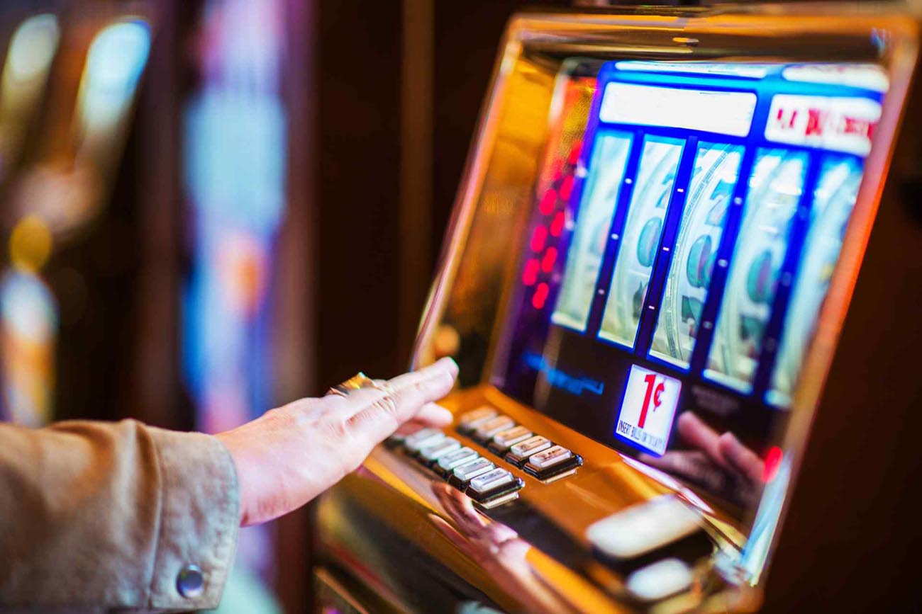 Woman Playing Classic Slot Machine in the Casino.