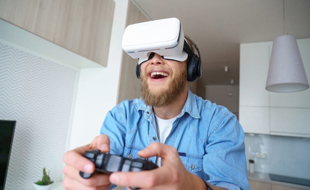 Gamer wearing vr glasses headset, holding gaming controller 