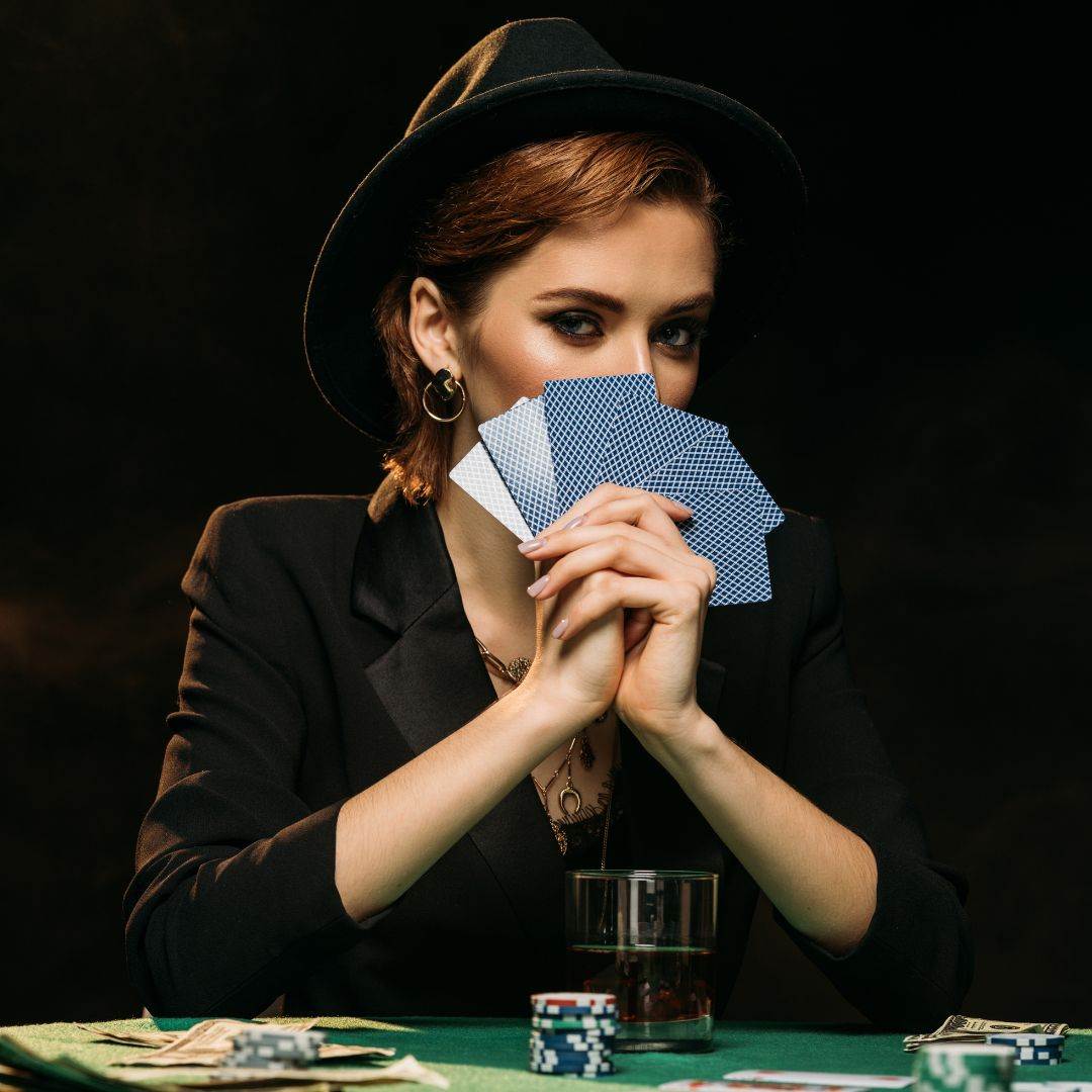 Woman covering face with cards
