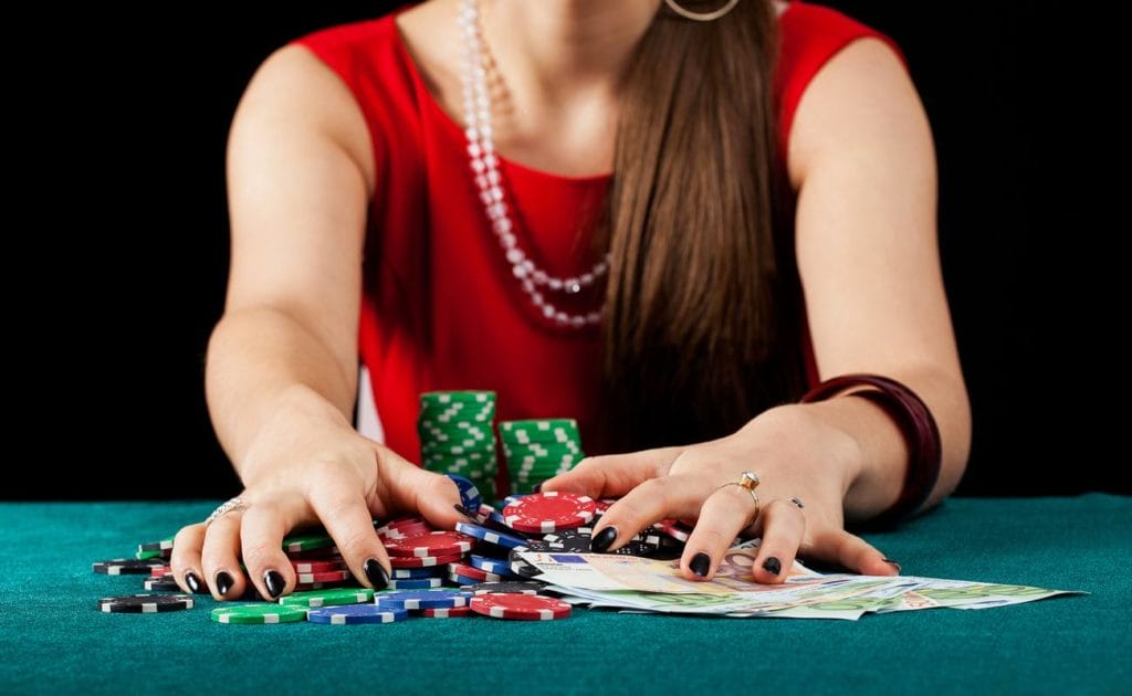 An elegant female gambler taking chips and banknotes