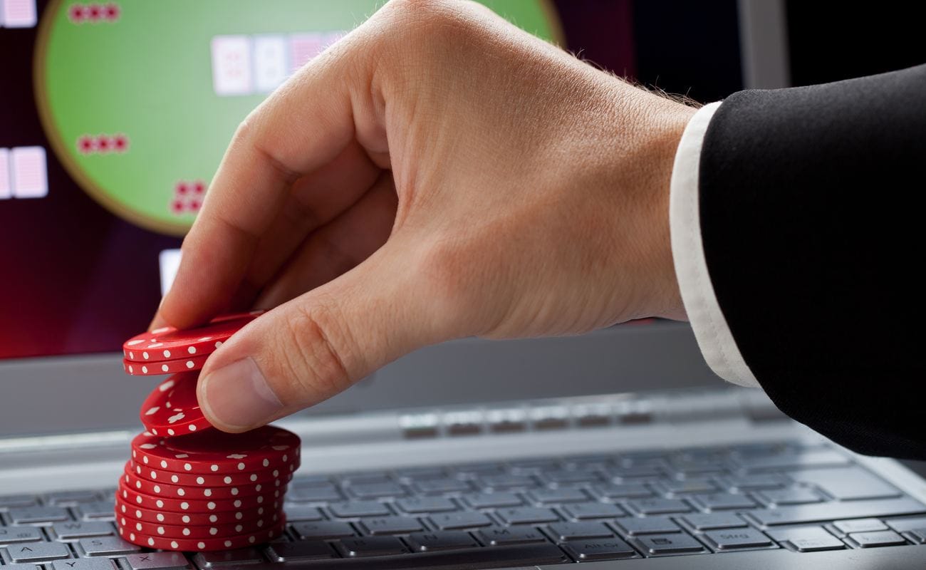 Player placing chips on a laptop which shows an online casino