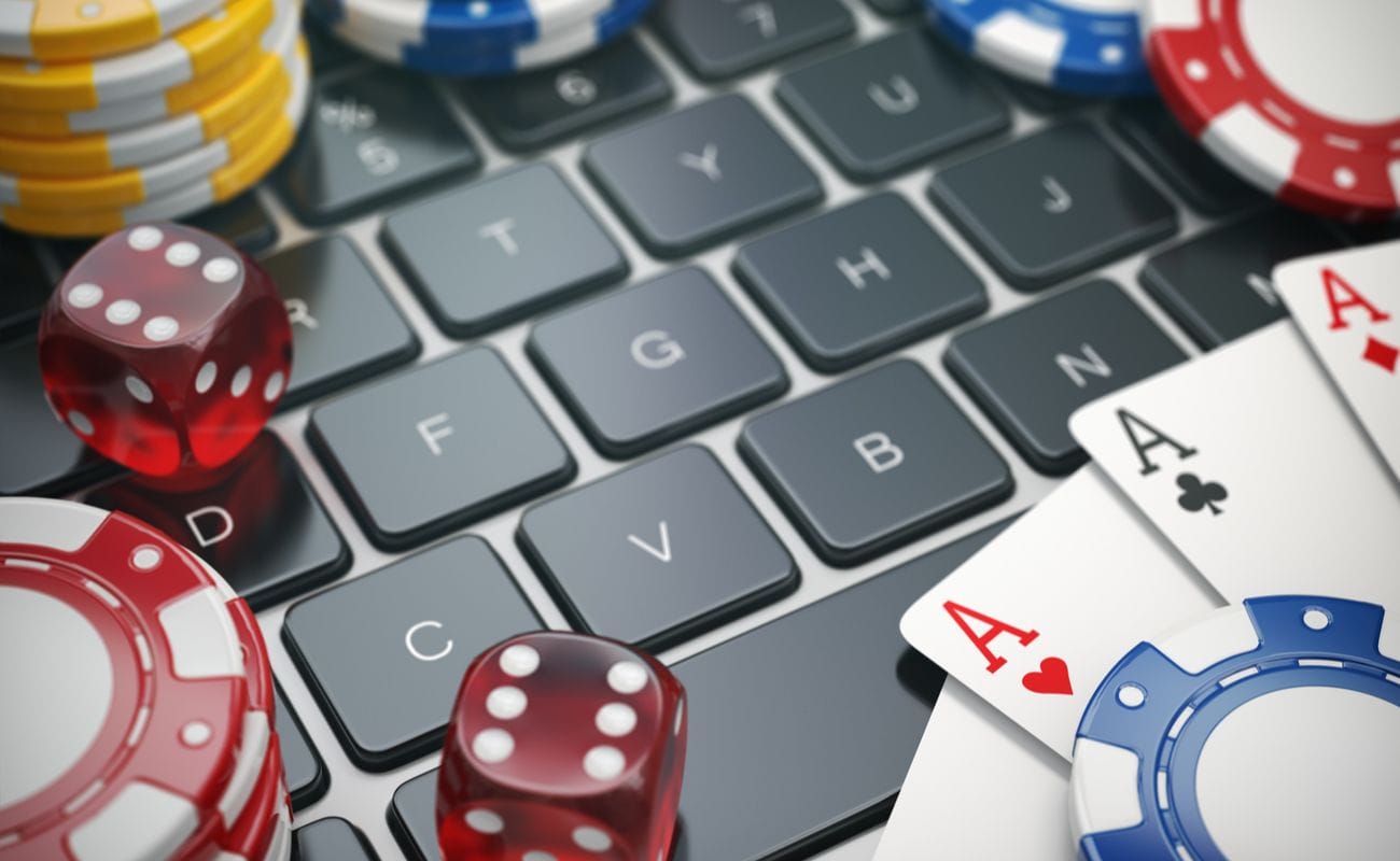 Gambling chips cards and dice on laptop computer keyboard background