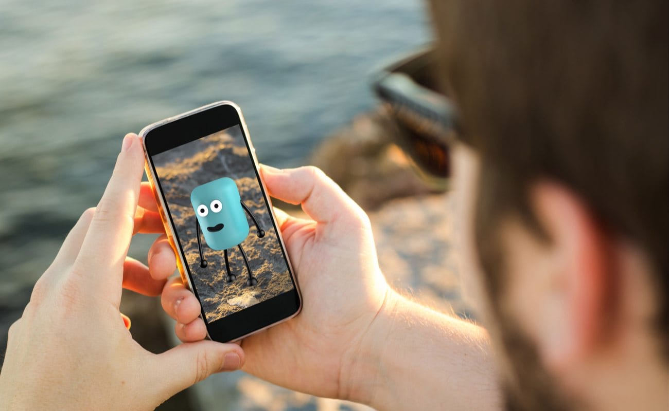 A man uses an augmented reality app at the beach