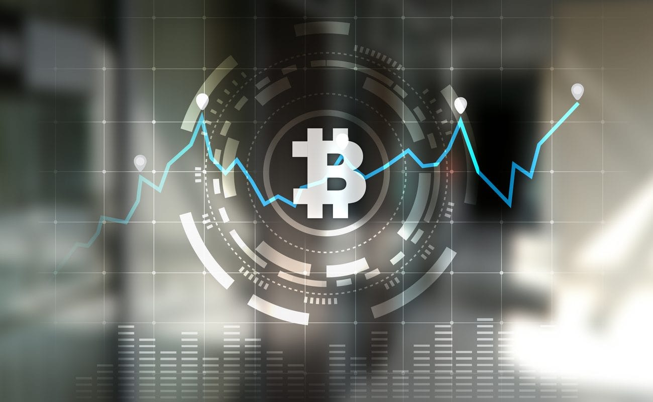 A line graph illustrating the rise and fall of cryptocurrencies in front of a symbol for Bitcoin