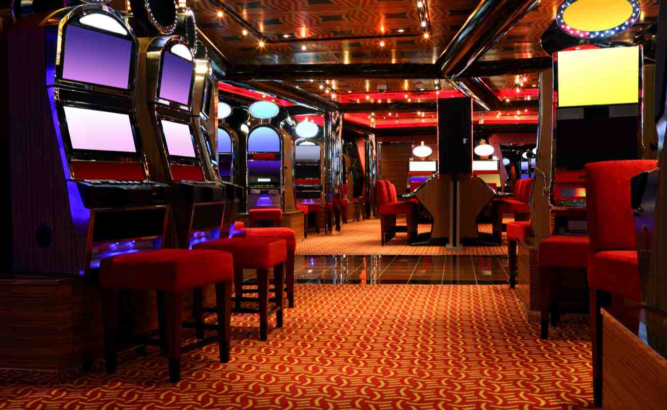 An empty casino with vacant machines and chairs.