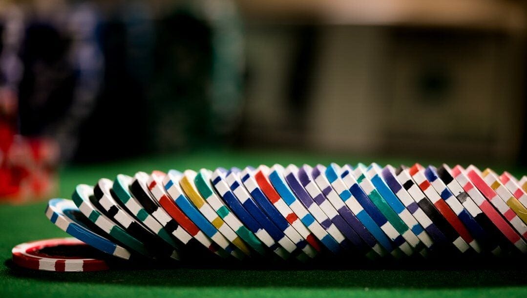 Stack of colorful gambling chips on a casino table.