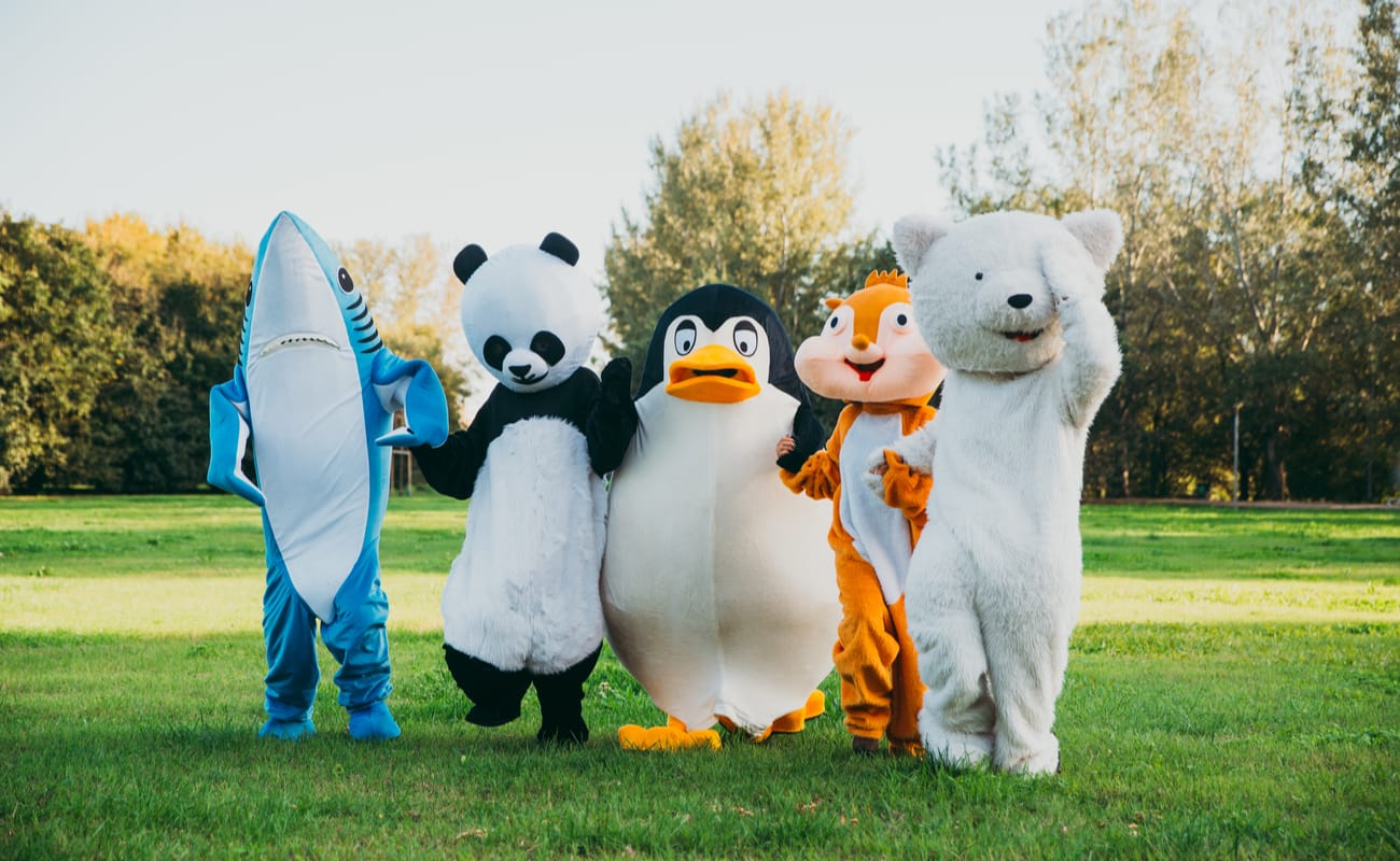 A shark, panda, penguin, chipmunk, and bear mascot walking together.