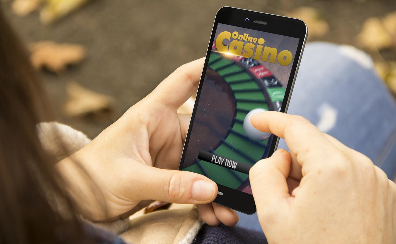 A woman playing online casino games on her smartphone.