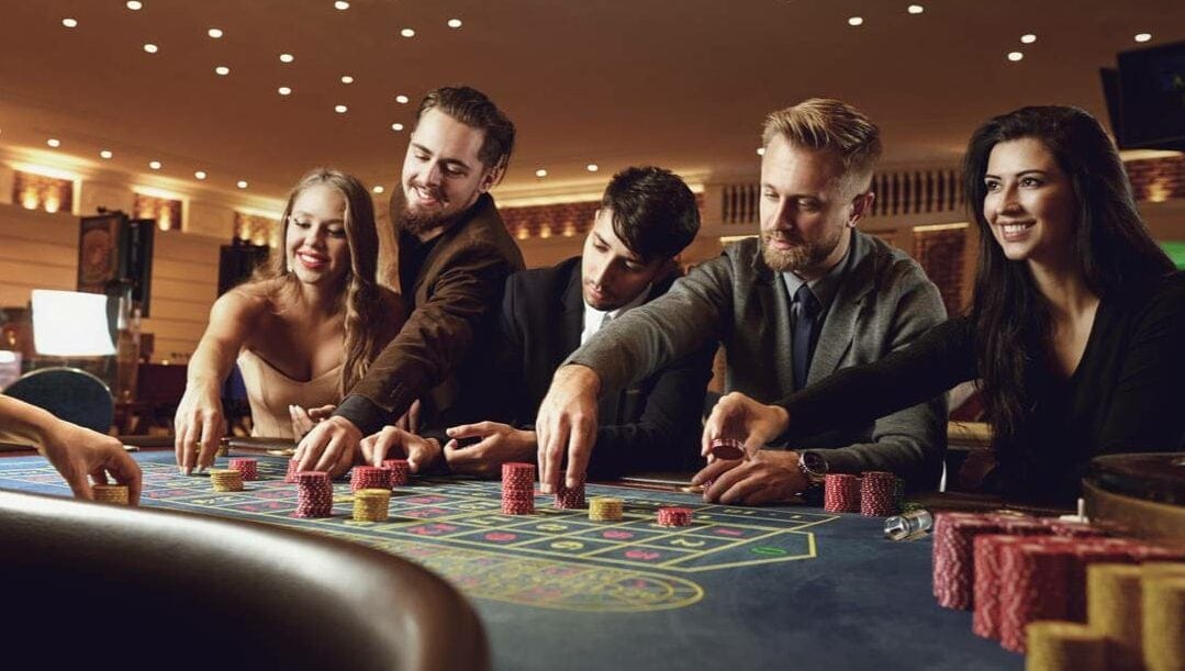 A group of gamblers placing their bets at a casino table.