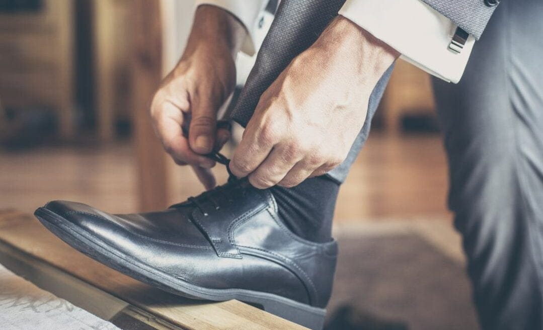 Man ties laces on formal shoes Ins and outs of footwear in casinos