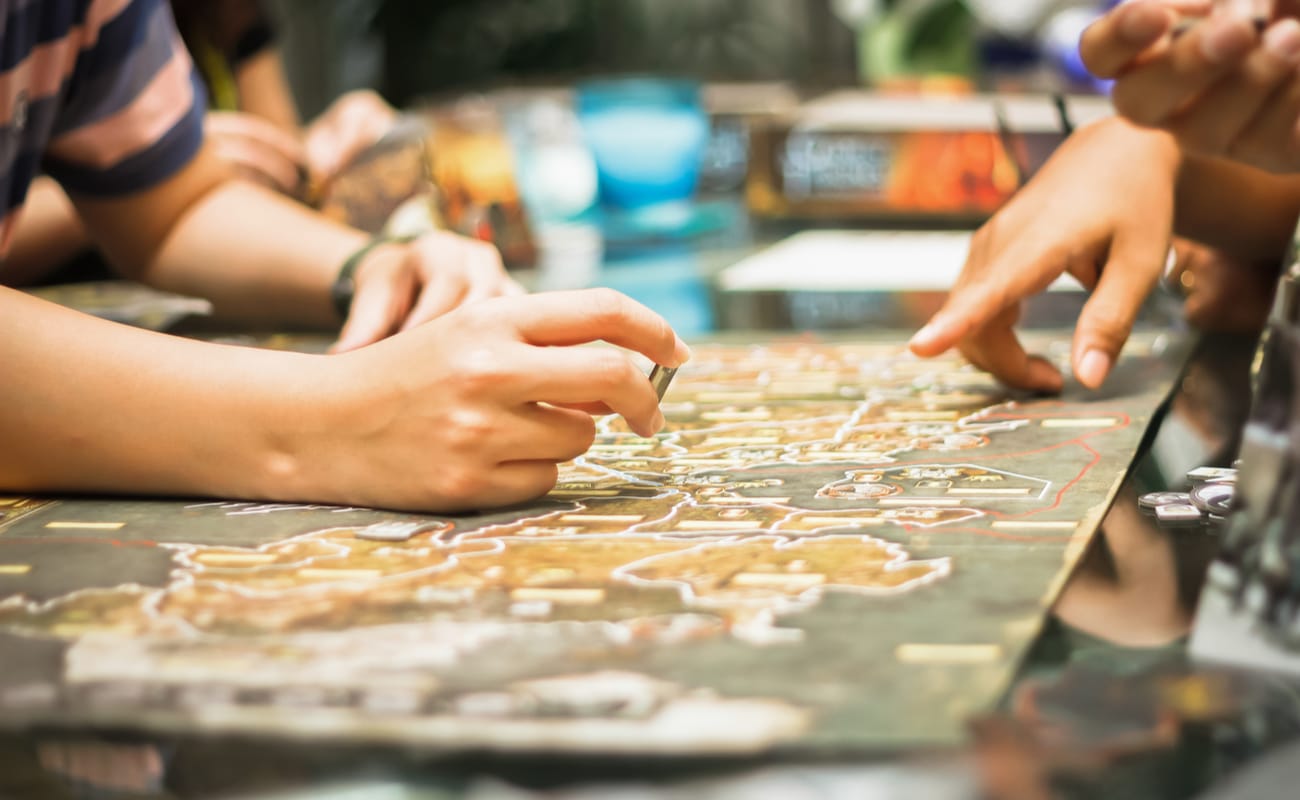 Close-up of people playing a board game.