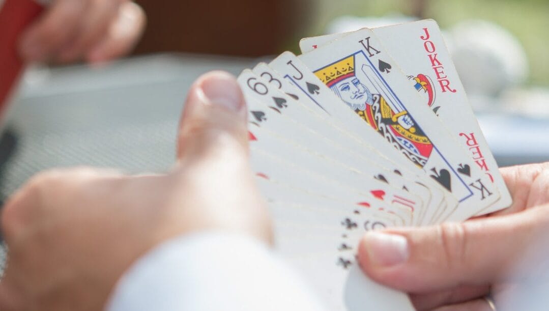 Playing cards with a finger covering some cards.