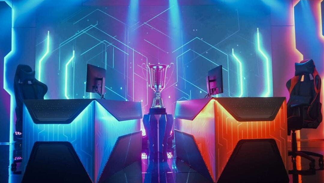 Esports championship arena with two opposing gaming stations and a trophy in the middle.