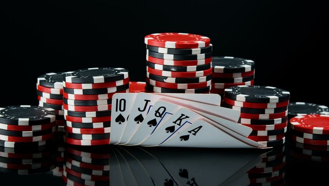 Poker chips and cards against a black background.