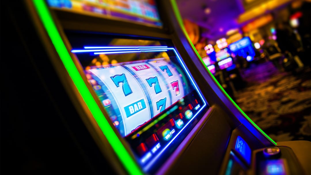 A slot machine in a casino with 7s and bar symbols.