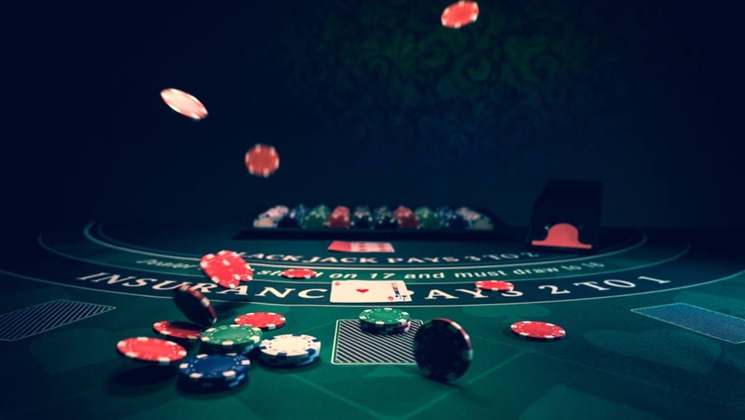 Casino chips and cards on a blackjack table.