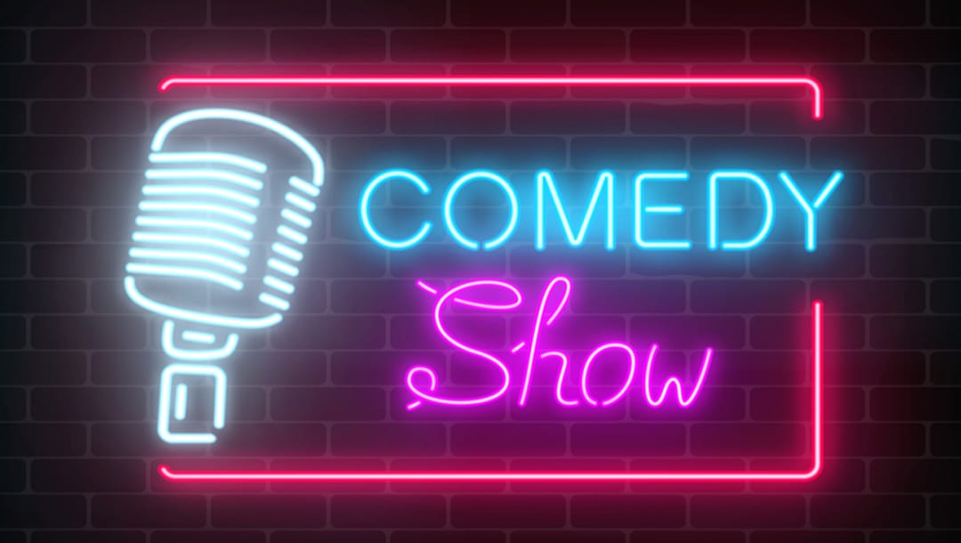 The word comedy written in neon lights alongside a stylized neon microphone.ast Decade