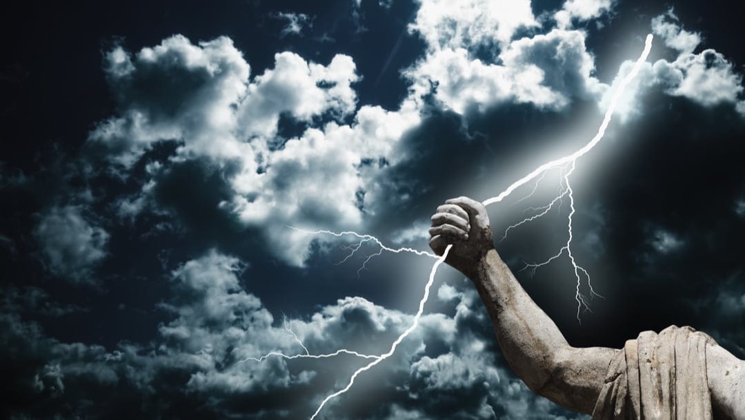 A close up of a statue of Zeus with his arm grabbing a lightning bolt
