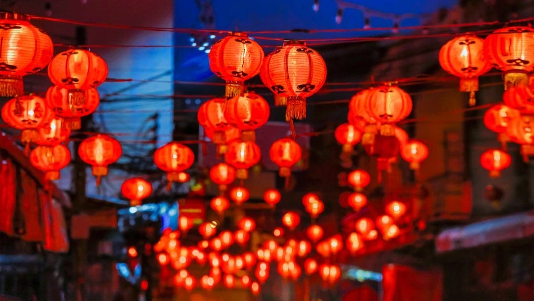 Traditional Chinese red lanterns lining a city street.