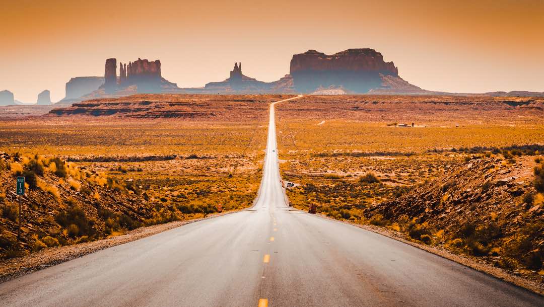 Classic panorama view of historic US Route 163 in golden evening light at sunset in summer.