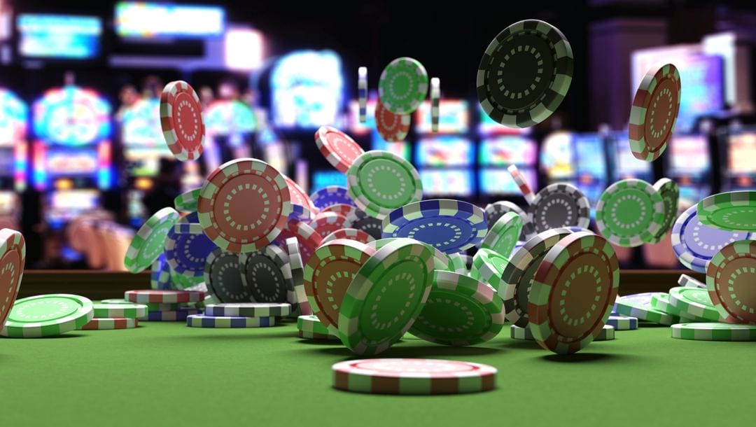 Poker chips flying around on a casino table with slot machines in the background.