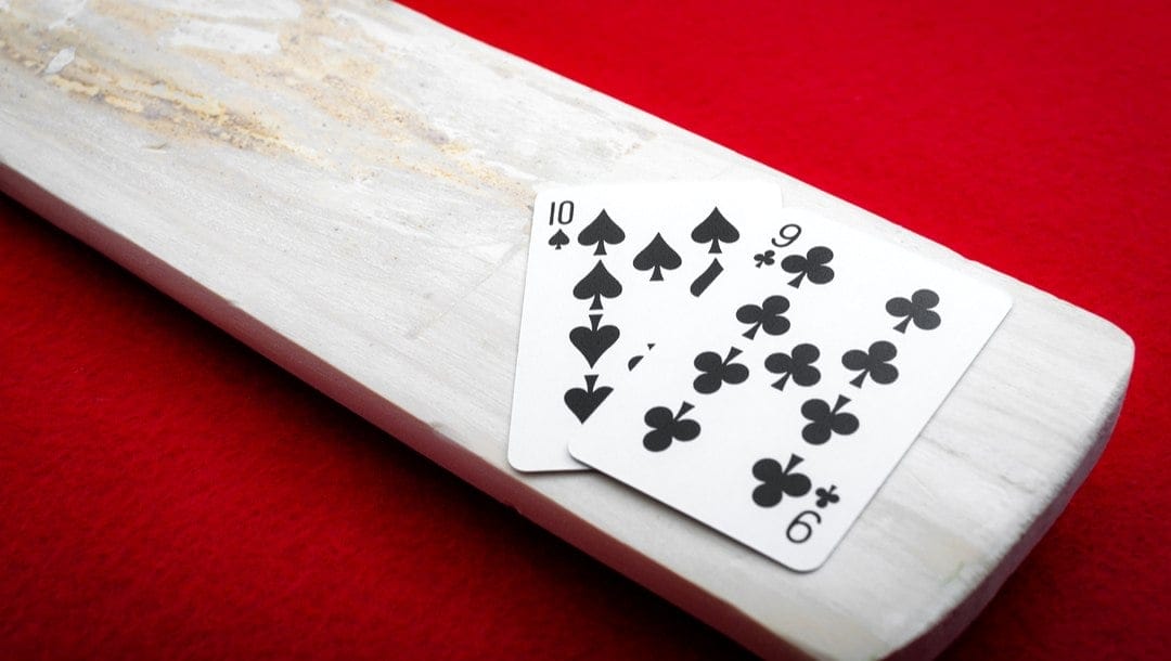 Winning baccarat hand on a wooden paddle on a red felt table.