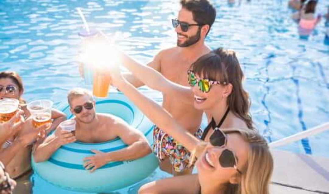 Smiling guests toast each other in the MGM Grand swimming pool.