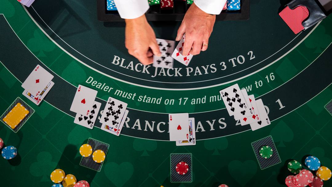 Blackjack dealer deals cards at the table.