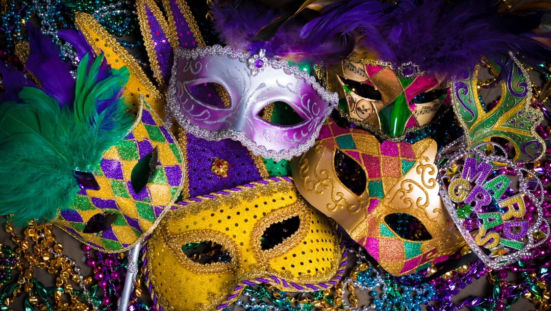 A selection of different masks and a crown with “Mardi Gras” on it.
