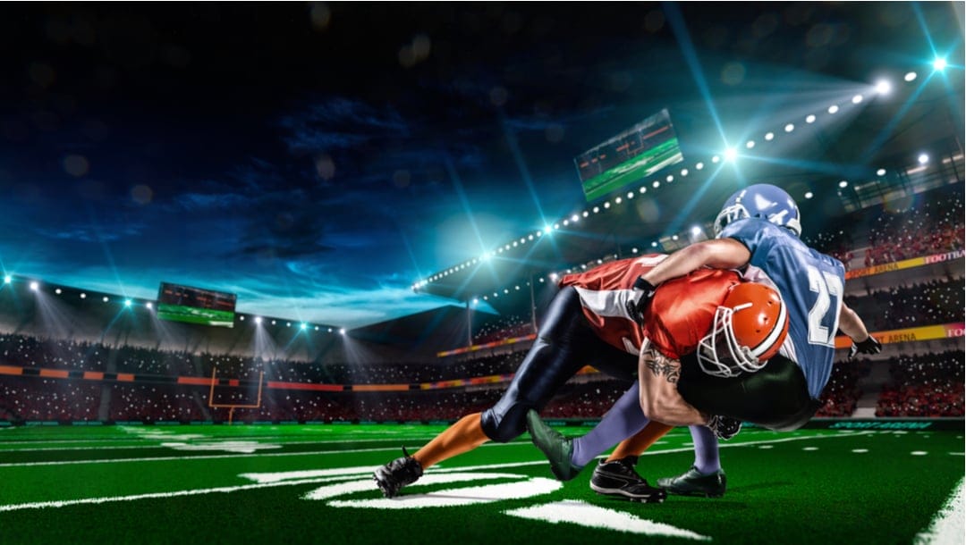 Two virtual football players in a tackle with a spectator-filled stadium in the background.
