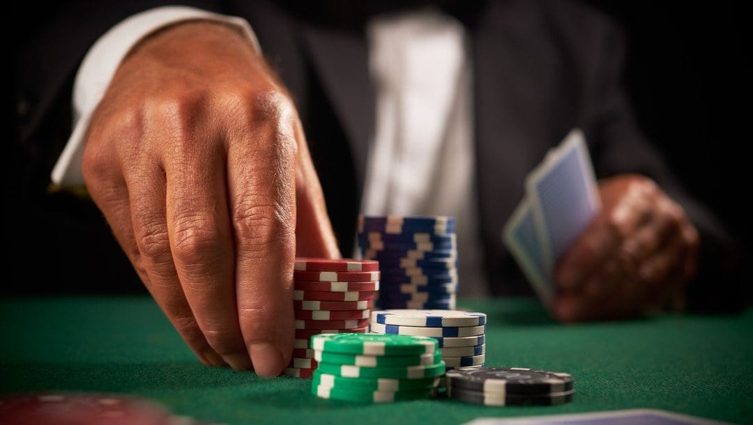 A poker player picks up a stack of chips.