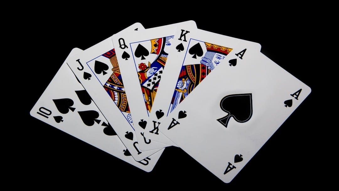 A straight flush in playing cards displayed on a black table