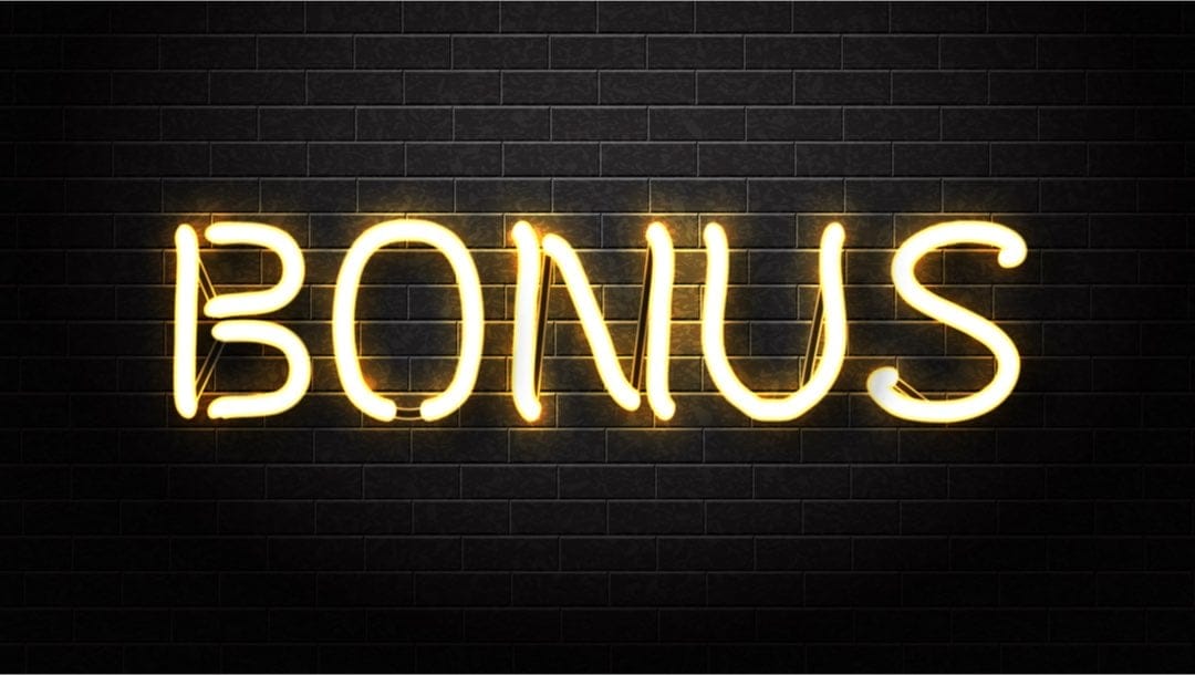 ‘Bonus’ written in lights against a dark wall.