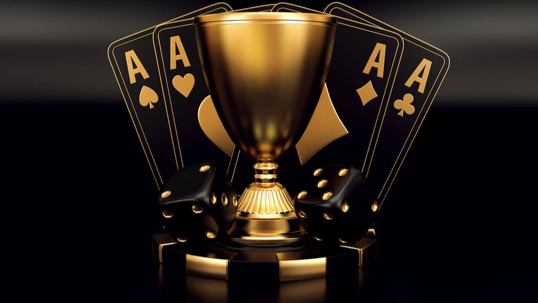 A trophy with black and gold ace cards and playing dice.