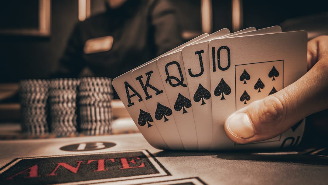 A poker player reveals a royal flush.