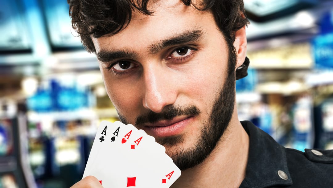 A poker player reveals four aces.