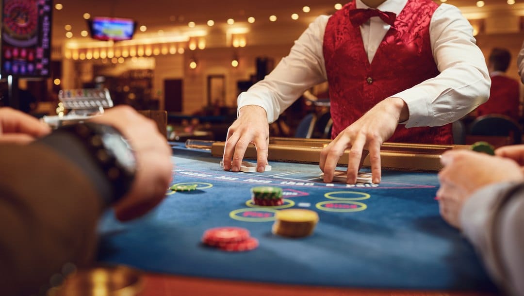 A poker dealer shuffles his cards between hands.