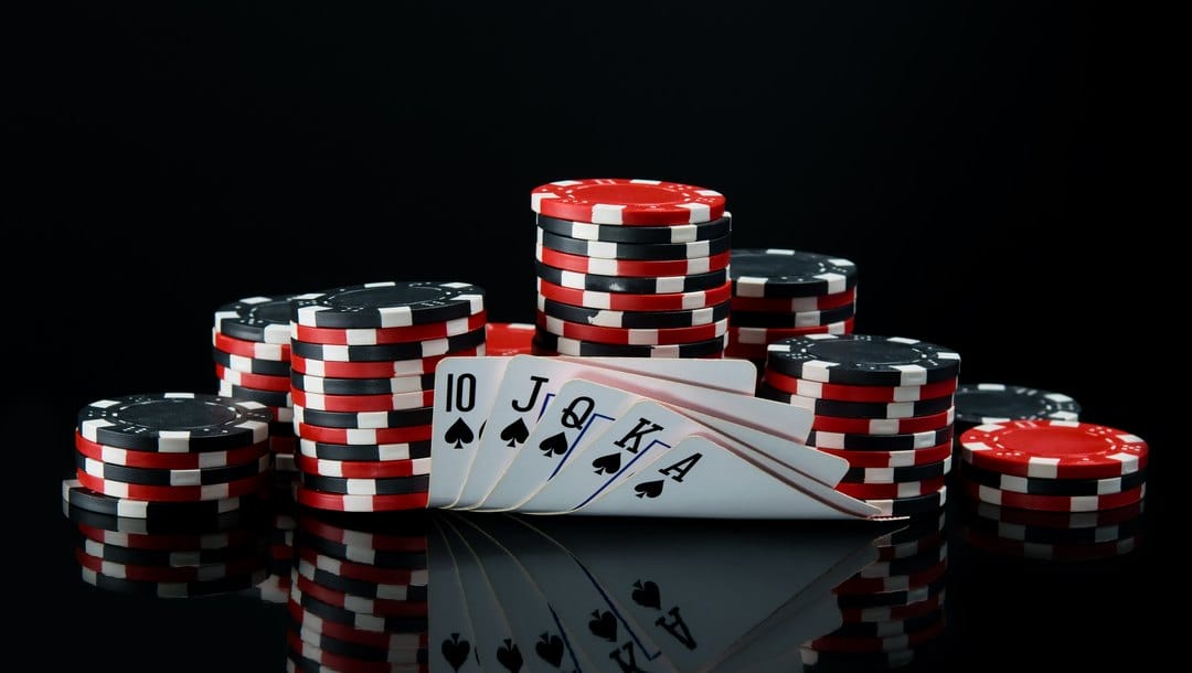 Poker chips and cards on a black surface.