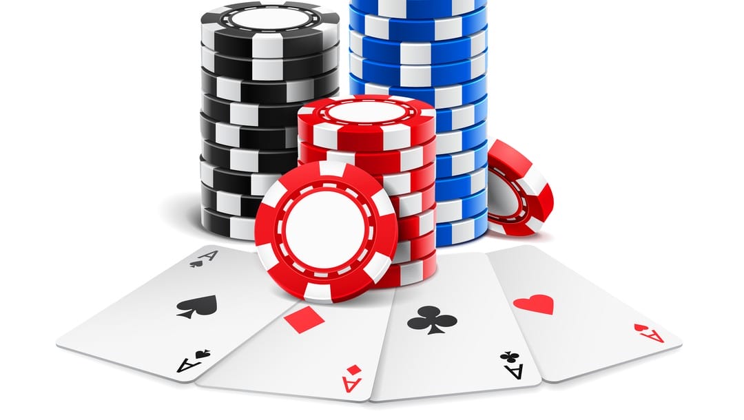 Three stacks of poker chips sit on top of four aces.