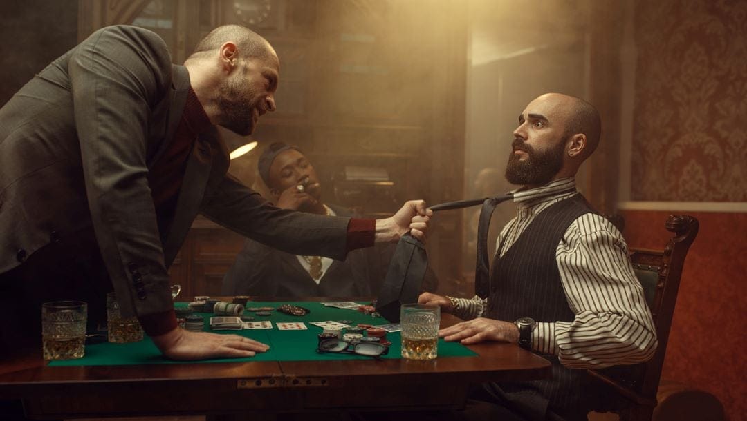 A poker player grabs an opponent by his tie.