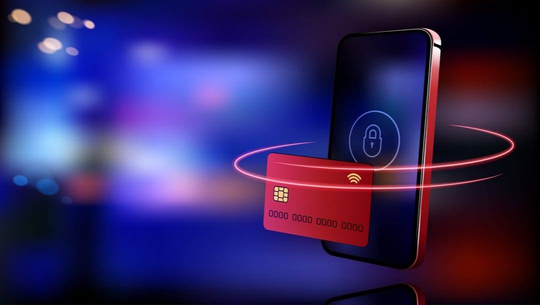 A credit card hovering over a smartphone with a lock symbol on it.