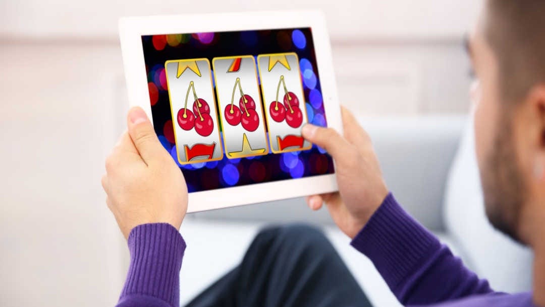 A man plays online slots on a tablet.