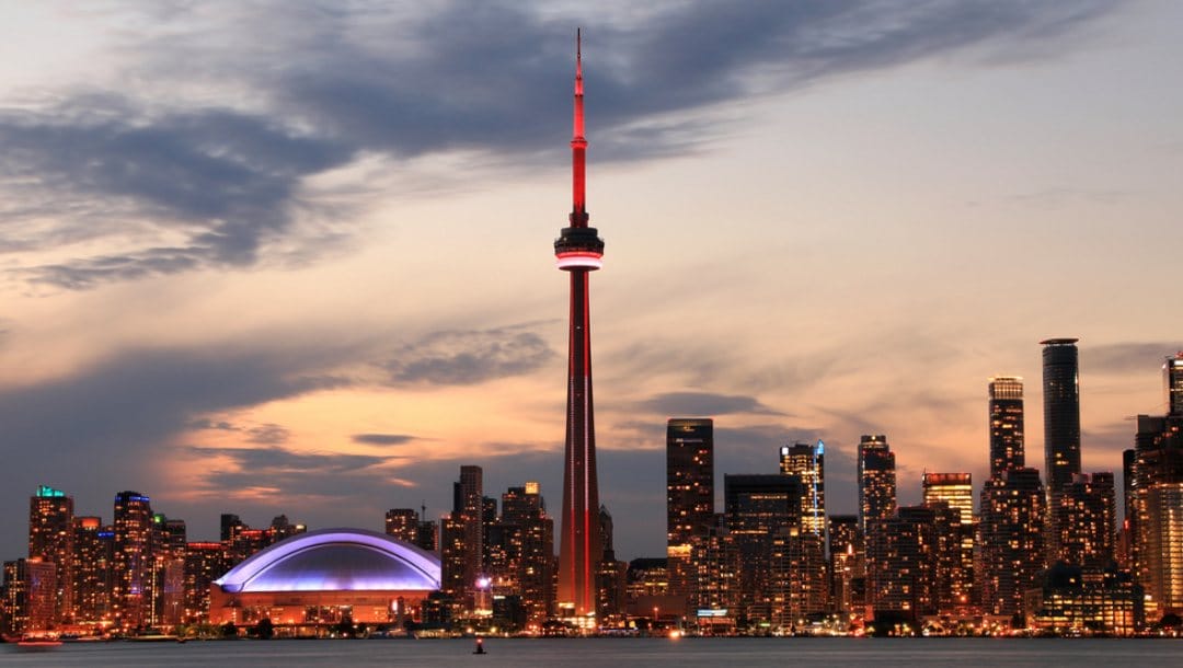 The CN Tower stands out against the Toronto skyline at dusk.