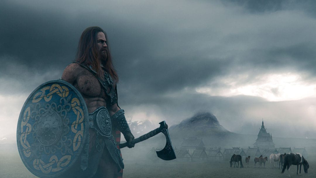 A Norse god-like character standing with a shield and axe with horses, tents, and mountains in the background.