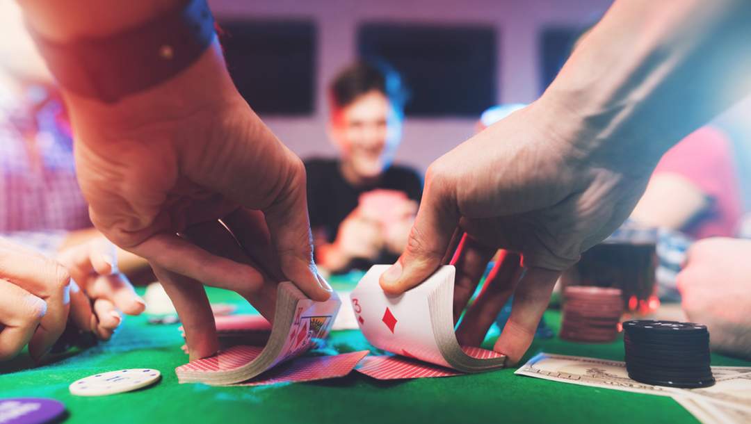 A person shuffles cards for a poker game.