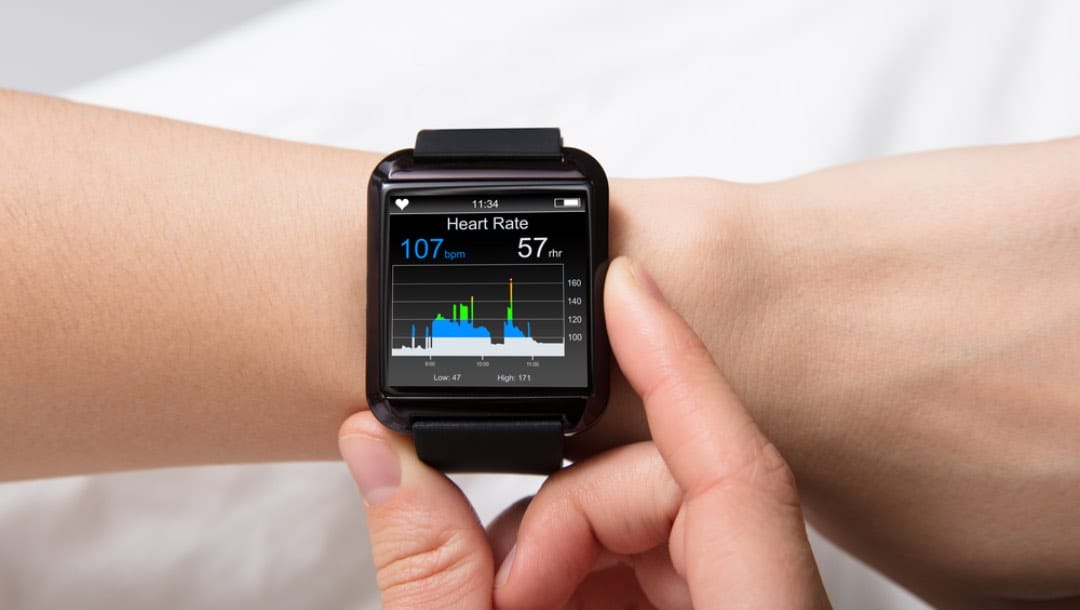 A person checks the heart rate monitor on their smartwatch.